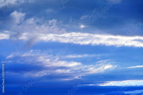 Curly clouds on a sunny day. Summer sky. Light cloudy, good weather. Beautiful bright blue background. Heaven and infinity. White clouds in the blue sky © watman