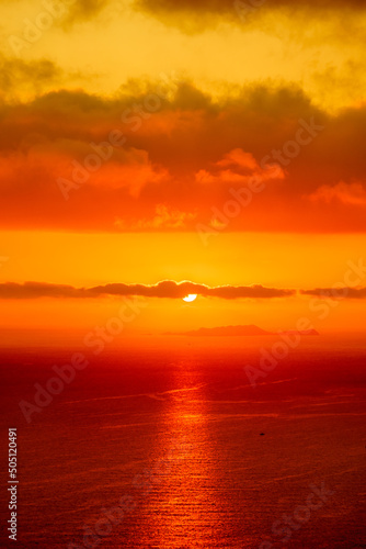 Red sun in the clouds. Colorful sunset in the evening sky. Great dramatic view. Clouds illuminated by the setting sun. Amazing sky panorama. Meditative calmness and greatness