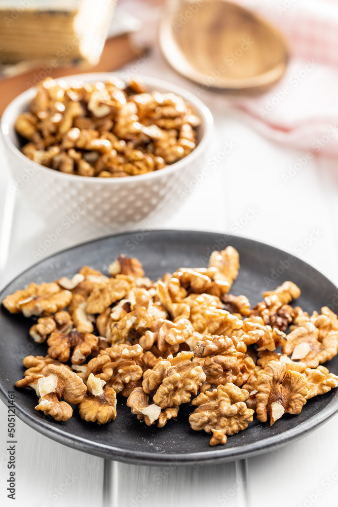 Peeled walnut kernels on plate on white table. Peeled walnut kernels on plate on white table.