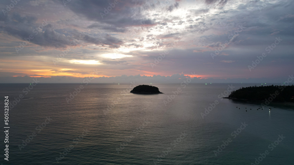 The red-orange sunset is reflected with clouds in the sea. An island can be seen in the distance. Smooth water is like a mirror. There is a lonely island. Not far from the shore of the boat. Epic The red-orange sunset is reflected with clouds in the sea. An island can be seen in the distance. Smooth water is like a mirror. There is a lonely island. Not far from the shore of the boat. Epic