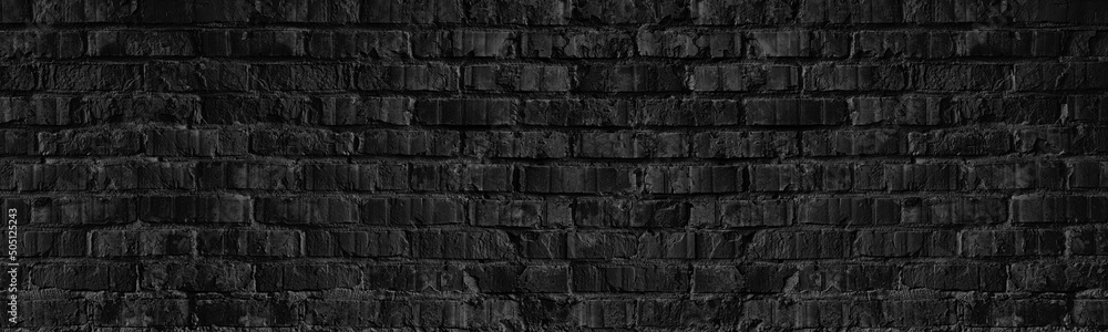 Old rough black brick wall wide texture. Gloomy grunge dark textured panoramic background
