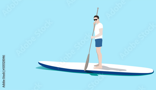 Young man standing on sup board floating in sea in sunny day. Tourist learning to paddle and balance on paddle board.