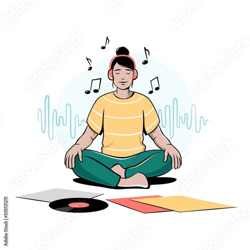 Girl, young woman sitting cross-legged, meditating and listening to music in headphones