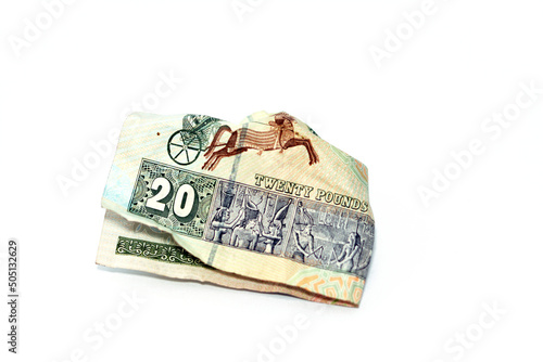 Crumpled Egyptian money of 20 LE twenty pounds isolated on white background, wrinkled 20 pounds cash bill banknote, Egypt money inflation and economy world crisis concept, selective focus photo