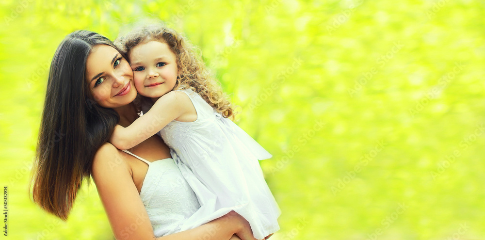 Portrait of happy smiling mother hugging little girl child on sunny summer background, blank copy space for advertising text Portrait of happy smiling mother hugging little girl child on sunny summer background, blank copy space for advertising text