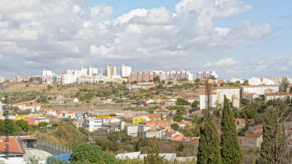 ighrise apartment towers and urban wasteland with shrubs and trees in the Penha Franca district in the suburbs of Lisbon, Portugal 