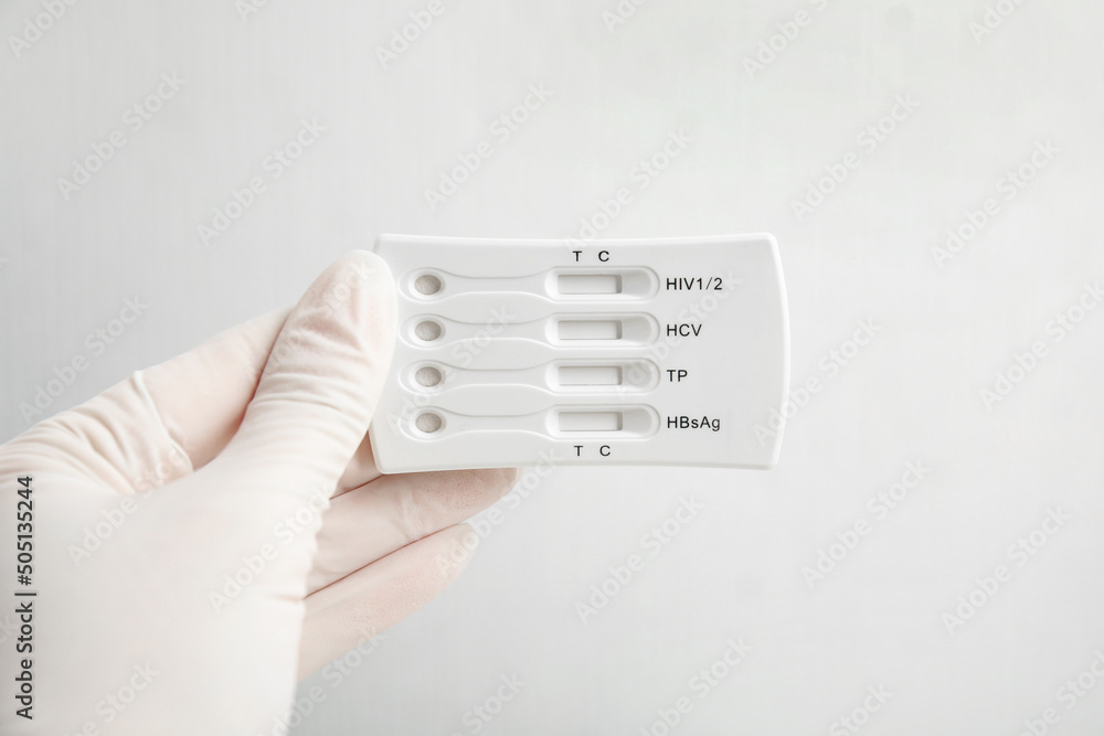 Doctor in gloves holding disposable express test for hepatitis on white background, closeup Doctor in gloves holding disposable express test for hepatitis on white background, closeup