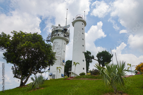 Bukit Jugra, Malaysia - April 16,2022: The lighthouse with the civilian radar system on the roof at the famous hiking and tourist spot on top of the Jugra hill, at the shore of the street of Malaka photo