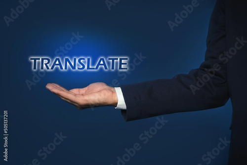 Man showing virtual model of word TRANSLATE against dark blue background, closeup