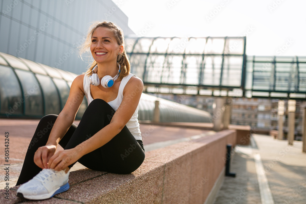 Portrait of attractive fit woman enjoying running, healthy lifestyle ourdoors in urban background.