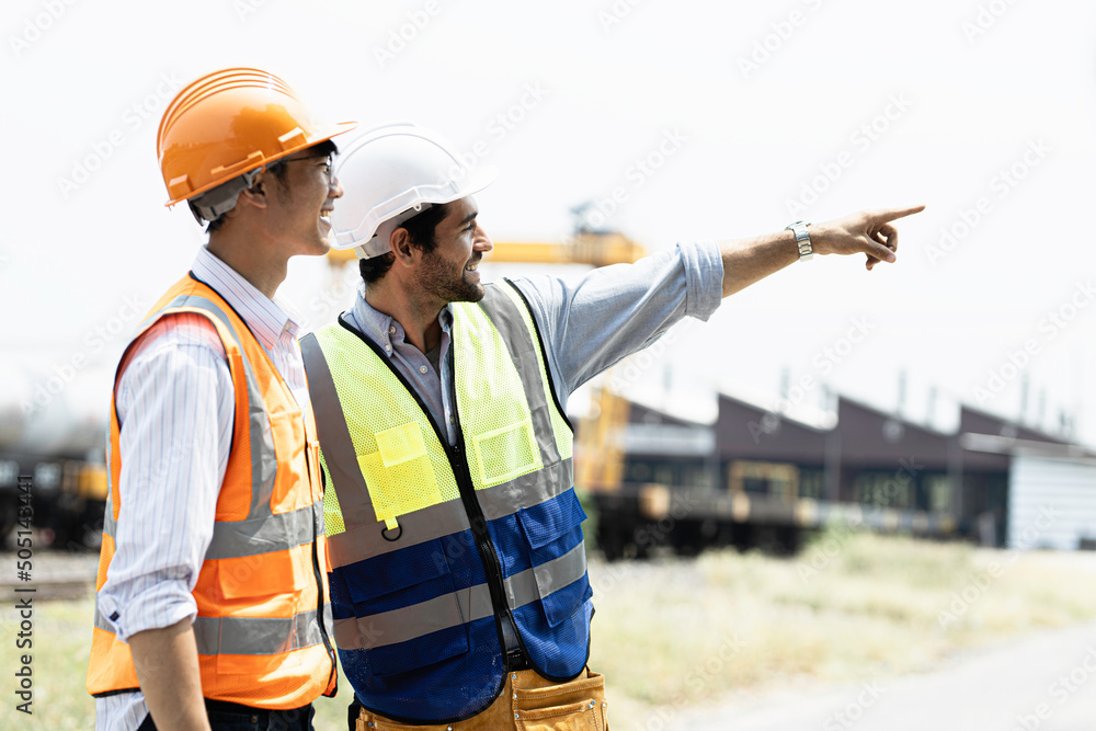 A team of male engineers stood at the rails chatting happily looking at their dreams.
