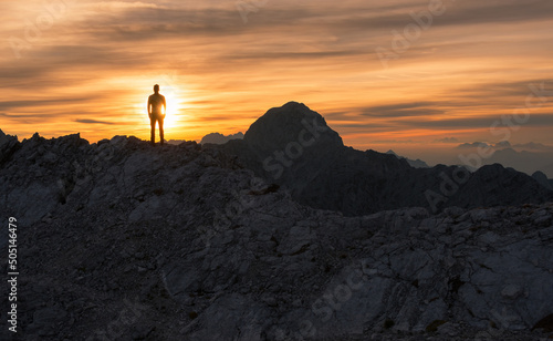 Male hiker at the top of the mountain at sunset