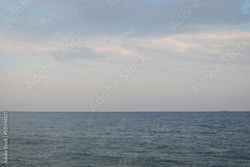 Calm sea with a ship sailing in the distance.