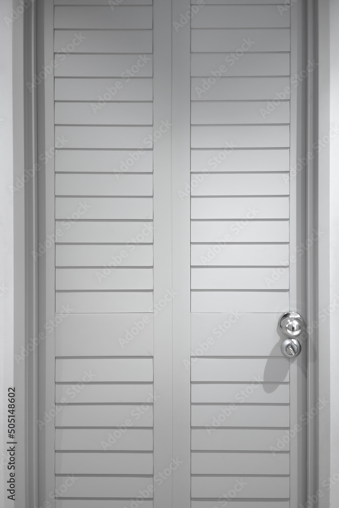Gray plank door with silver handle. Close-up photo. Entrance door Gray plank door with silver handle. Close-up photo. Entrance door