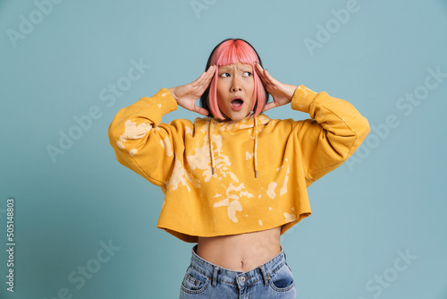 Carta da parati Asian girl with pink hair and piercing expressing surprise at camera