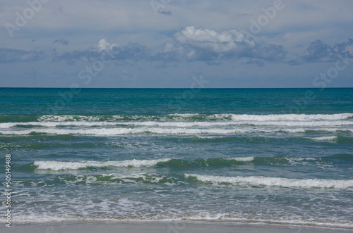 Beautiful white waves in the sea with blue sky background