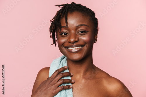 Black shirtless woman with towel smiling and looking at camera