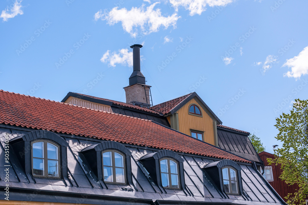 Roofs, dorms and chimney of old 1700s houses a sunny day in Stockholm