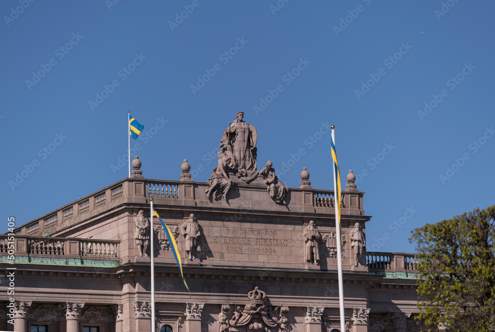 Obraz premium The Parliament house entre roof statues with Swedish flags a sunny day in Stockholm