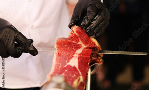 Traditional cut of Iberian ham with a knife photo