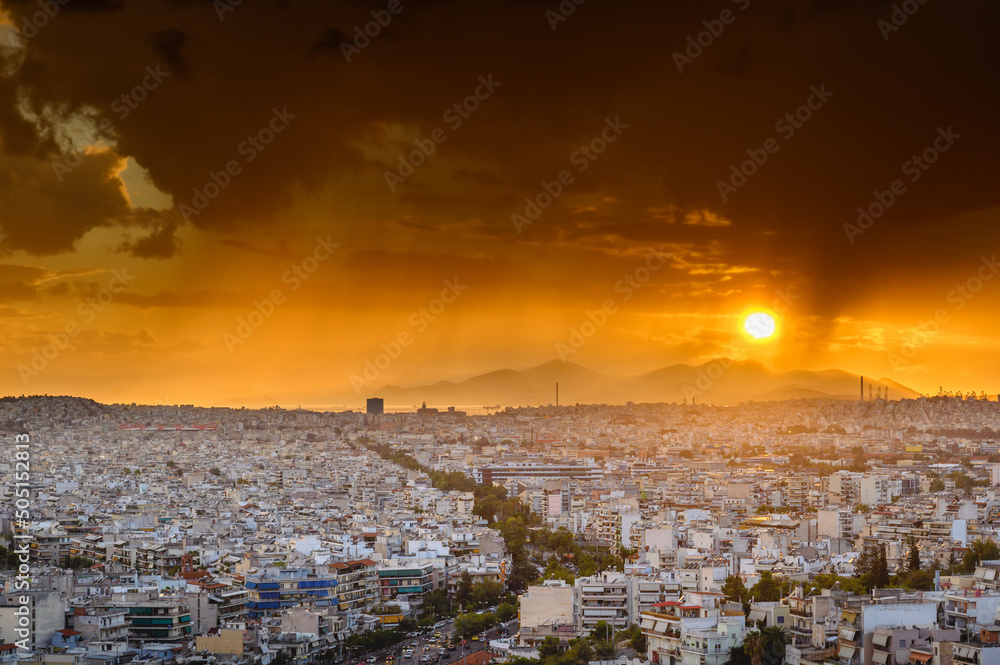 Panorama of the Greek capital Athens at sunset with a sky overcast with thunderclouds, Greece, Europe. View of the city from above.