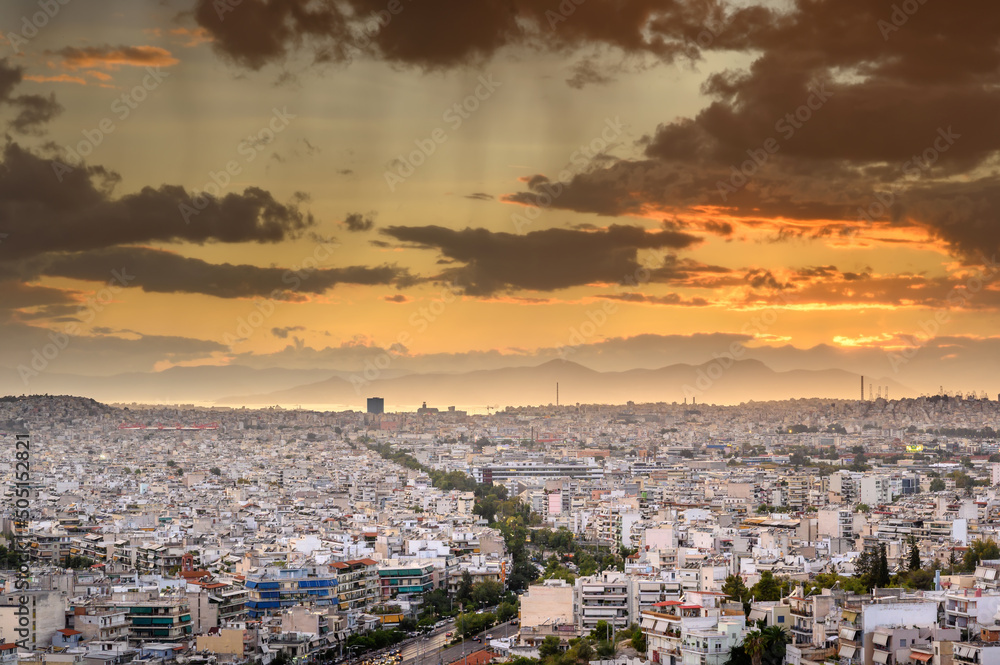 Panorama of the Greek capital Athens at sunset with a sky overcast with thunderclouds, Greece, Europe. View of the city from above.