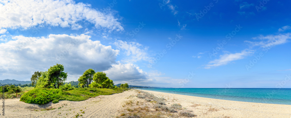 Landscapes view of beach sea sand and sky in summer day. Mediterranean Sea rolling in sunshine to the sandy beach.