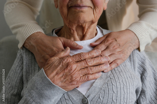 Billede på lærred Unrecognizable female expressing care towards an elderly lady, hugging her from behind holding hands
