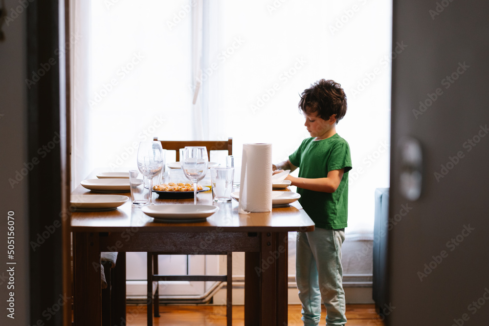 elementary caucasian boy preparing the table for lunch elementary caucasian boy preparing the table for lunch