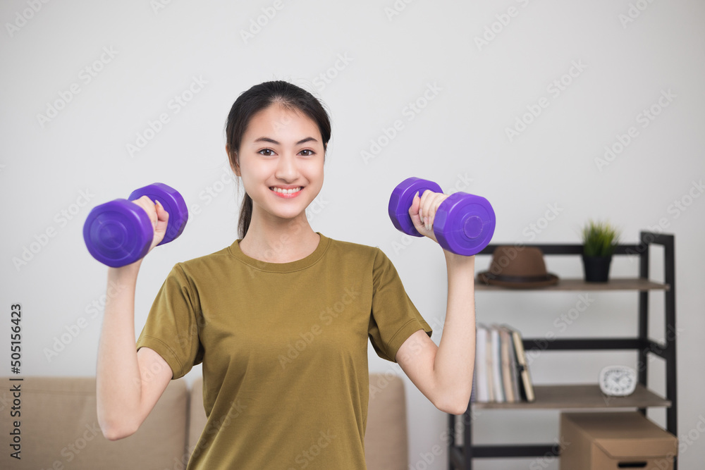 Attractive asian young fitness woman lifting dumbbell weights workout at home in living room. Fresh feeling female training and exercise wearing sport wear fit body. Attractive asian young fitness woman lifting dumbbell weights workout at home in living room. Fresh feeling female training and exercise wearing sport wear fit body.