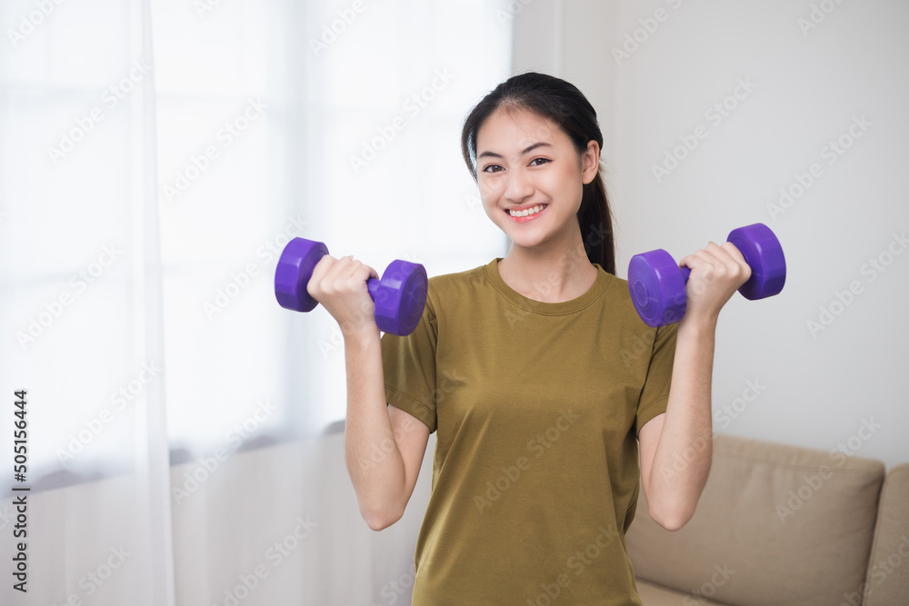 Attractive asian young fitness woman lifting dumbbell weights workout at home in living room. Fresh feeling female training and exercise wearing sport wear fit body. Attractive asian young fitness woman lifting dumbbell weights workout at home in living room. Fresh feeling female training and exercise wearing sport wear fit body.