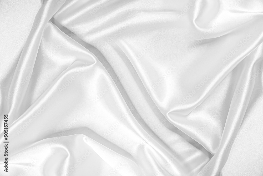 Closeup of rippled white silk fabric. White silk fabric as an abstract background. Closeup of rippled white silk fabric. White silk fabric as an abstract background.