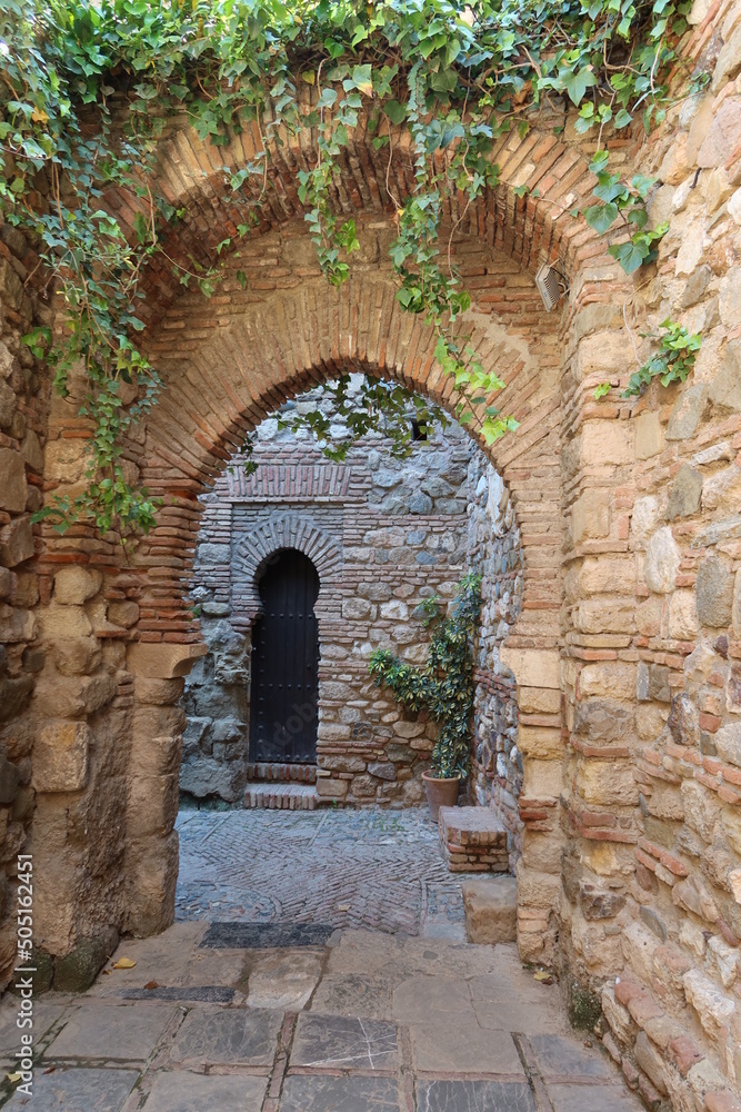 Malaga, Spain, May 8, 2022: Nasrid arches in the interior corridors of the Alcazaba of Malaga. Palatial fortification from the Islamic era built in the 11th century