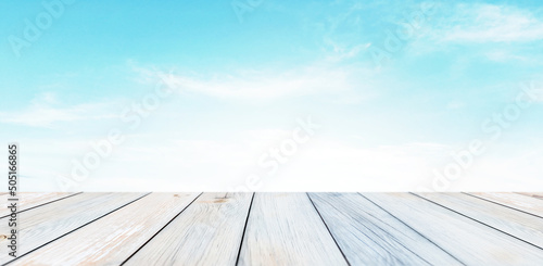 bright, cean wooden desk on summer sun with clouds in background for product presentation photo