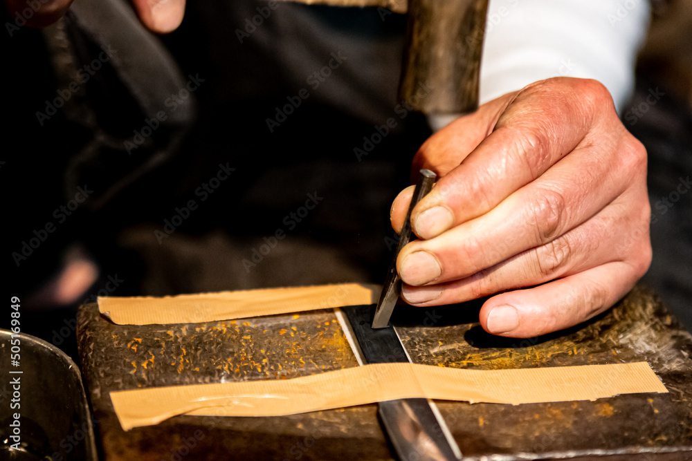 Carving a name into a metal blade of a Japanese katana samurai sword Carving a name into a metal blade of a Japanese katana samurai sword