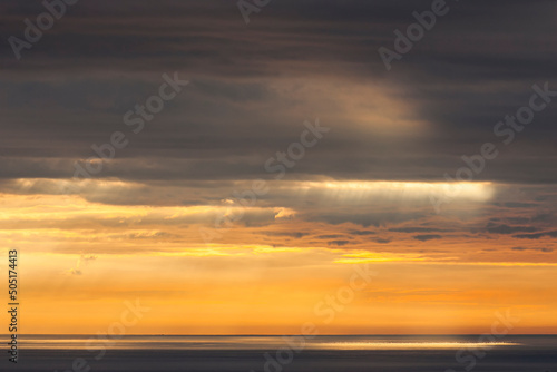 Summer sunrise with golden light breaking through nimbostratus clouds over the Irish Sea. Dublin  Ireland