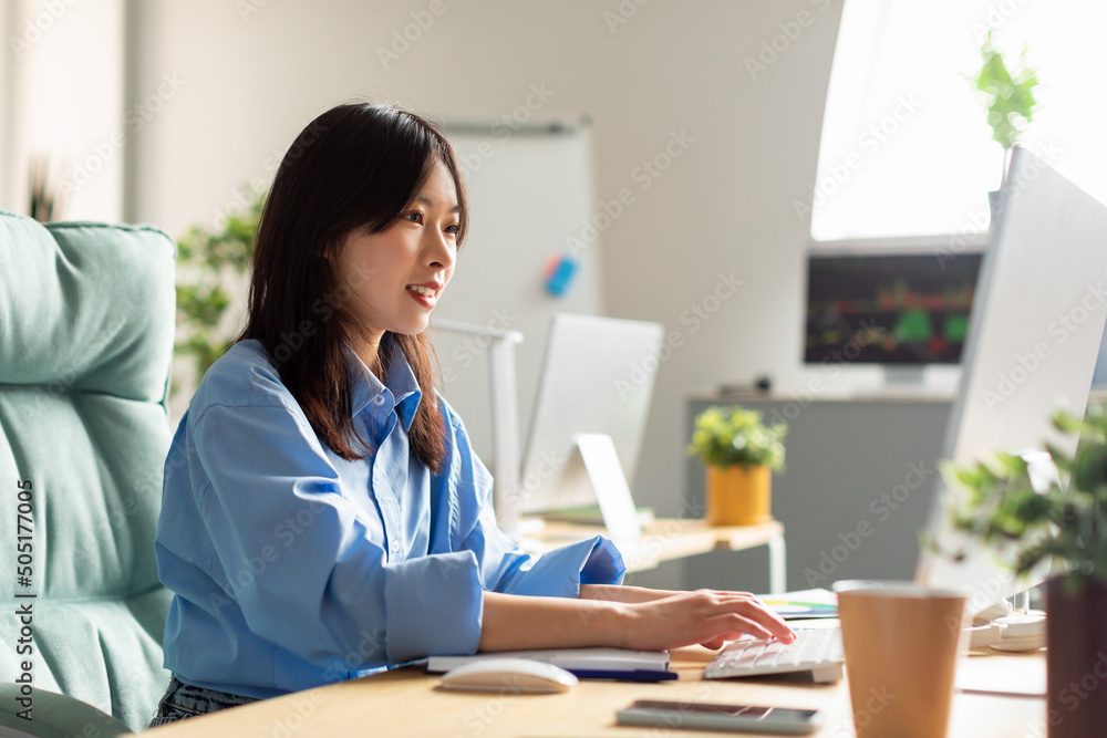 Portrait of smiling Asian woman using laptop at home office Portrait of smiling Asian woman using laptop at home office