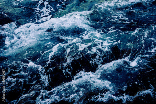 Dramatic sea waves storm from aerial view. Deep dark blue ocean water texture background. Top view. Fine art photography of stormy seascape from above.