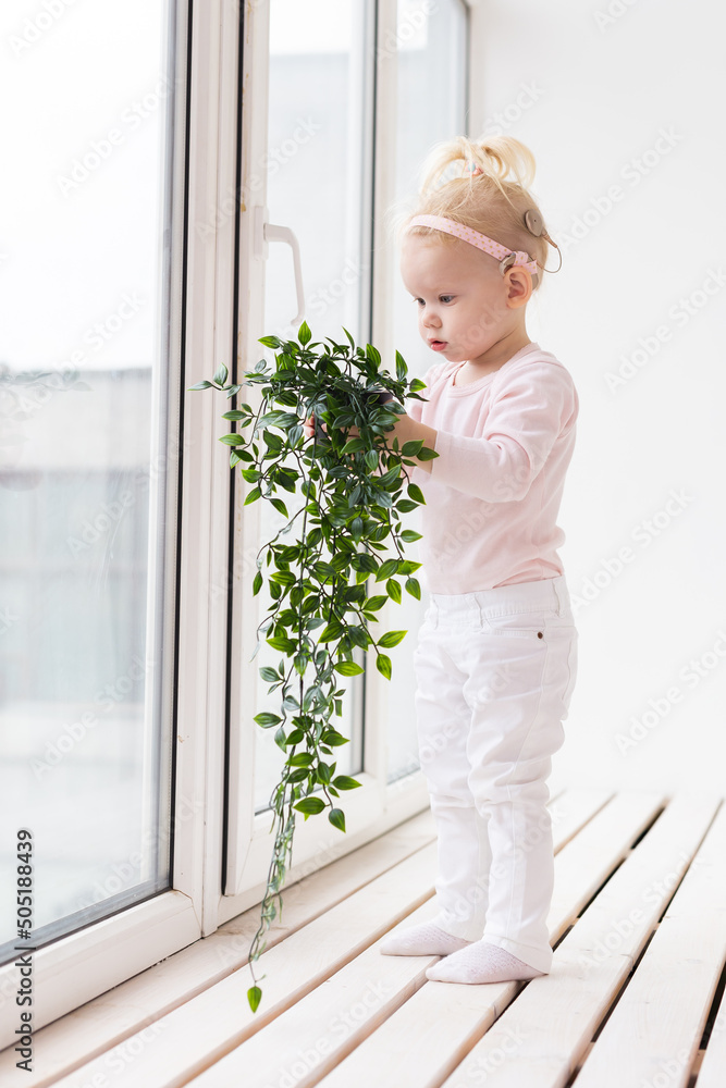 Baby with cochlear implants at home. Deafness and medical technology and diversity concept. Baby with cochlear implants at home. Deafness and medical technology and diversity concept.