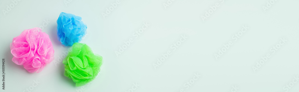 top view of multicolored body puffs on grey background, banner.