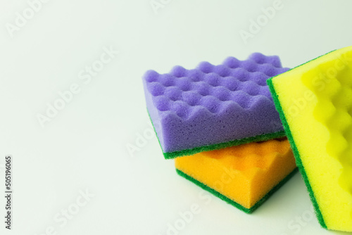 purple, orange and yellow sponges on grey background.
