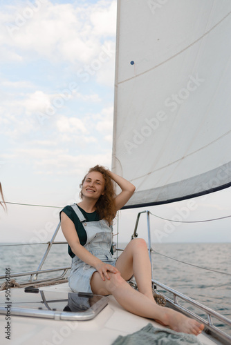 Portrait of a young woman on a yacht in the middle of the sea in summer