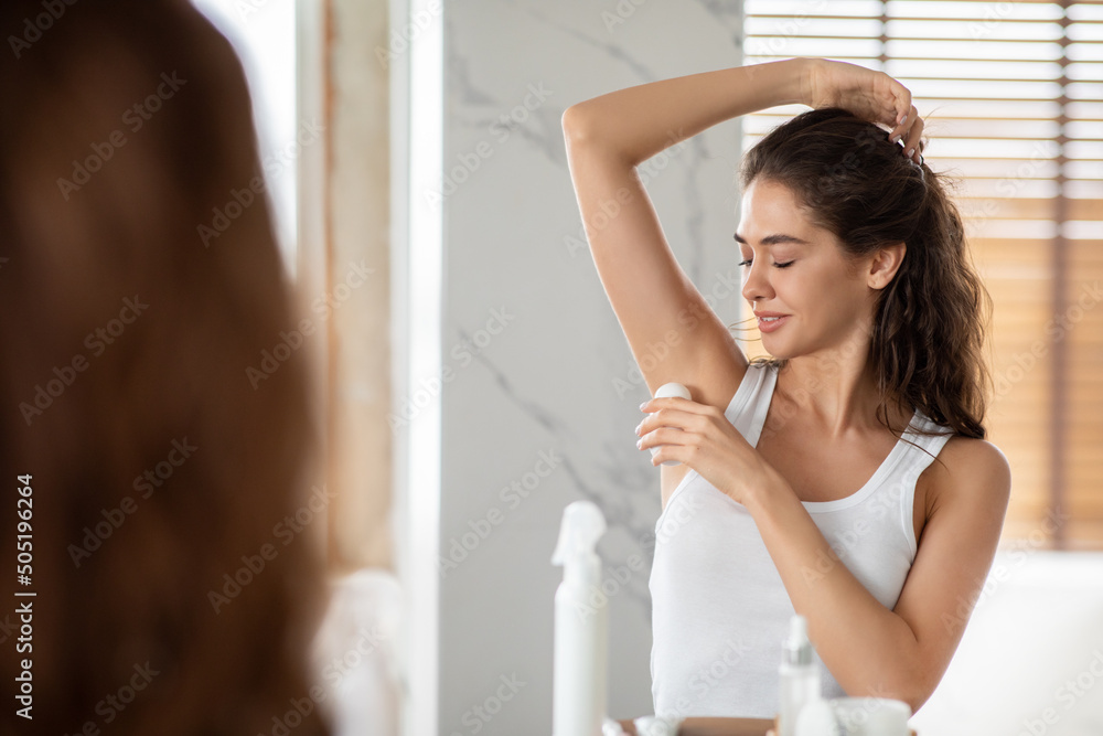 Lady Applying Antiperspirant On Armpit For Freshness In Modern Bathroom Lady Applying Antiperspirant On Armpit For Freshness In Modern Bathroom