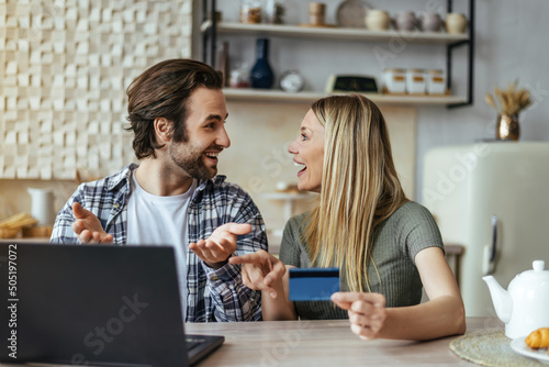 Smiling surprised european young couple rejoice successful buy and sale, online shopping with laptop and credit card