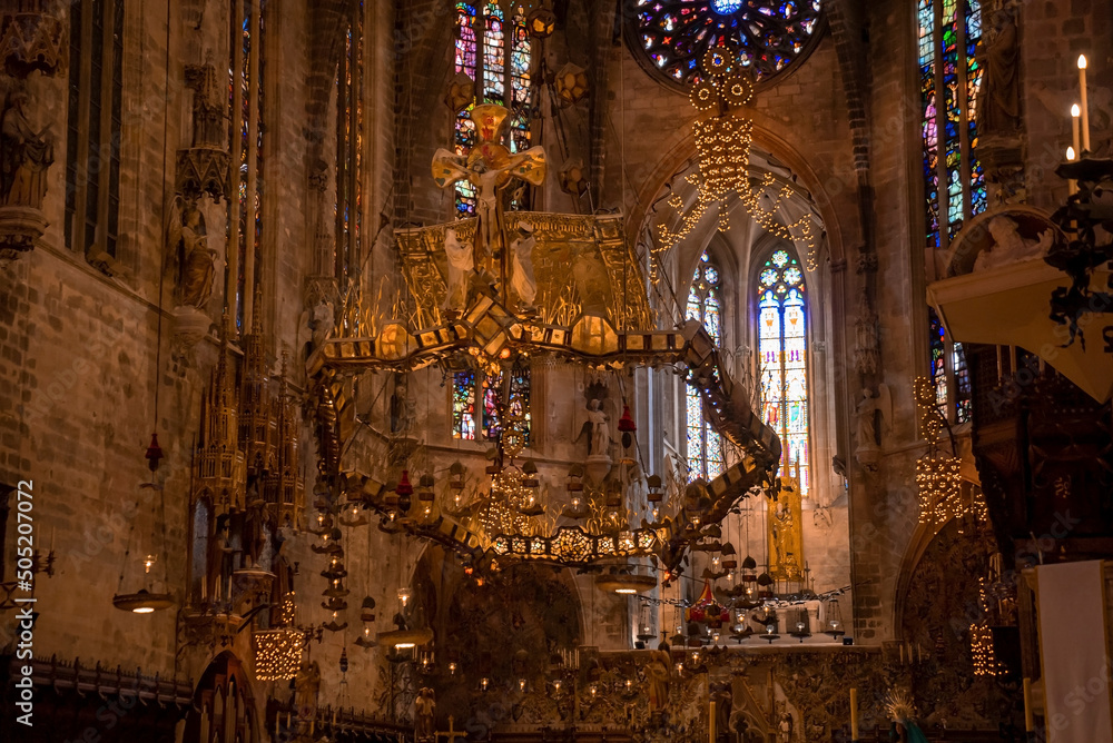 Low angle view of beautiful altar in medieval La Seu Cathedral. Creative decoration hanging over gothic church. Interior of old religious building.
