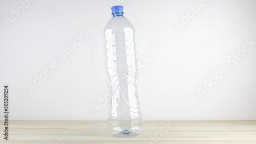 Stop-motion animated video of the proper way of recycling plastic bottles. It shows if the bottles are compressed the recycling container can fit much more of them. Tutorial loop video, eco concept.