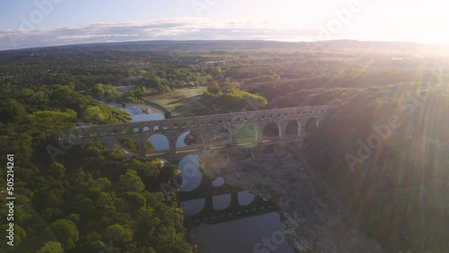 Vue aérienne panoramique en drone au lever du soleil, au dessus du Pont du Gard, aqueduc construit par les romains, près de Nimes, dans le sud de la France, classé au patrimoine mondiale de l'Unesco photo