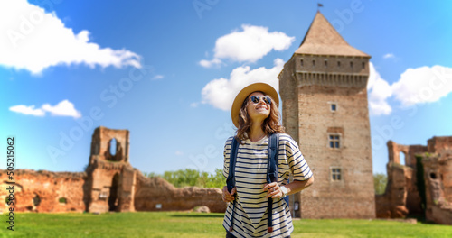Young happy woman traveling around Serbia, against the background of a medieval fortress in Bac city photo