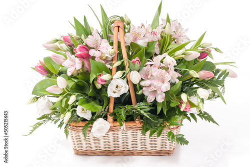 Beautiful bouquet of bright flowers in basket . Isolated on white. Springtime. Basket with tulips.