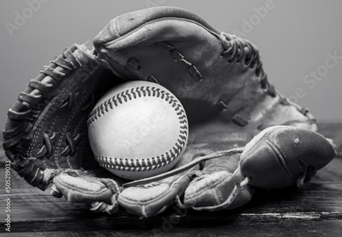 Black and white photo of a baseball resting in a Baseball glove 